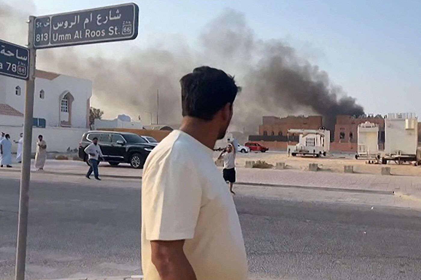 Cette image montre un homme regardant la fumée qui s'élève après les explosions survenues à Doha, capitale du Qatar, le 9 septembre 2025. Un responsable militaire israélien a déclaré que l'armée avait mené des frappes aériennes sur Doha le 9 septembre dans le cadre d'une opération visant les hauts dirigeants du groupe terroriste palestinien Hamas